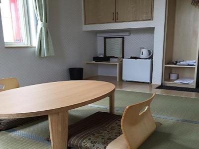 a living room with a table and chairs, Petit Hotel Blanc Fleur in Furano