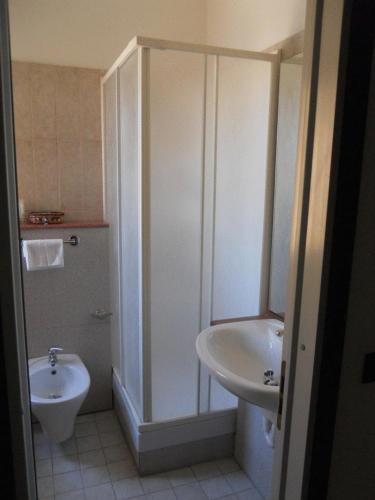 a bathroom with a toilet, sink, and shower, Hotel Traghetto in Civitavecchia
