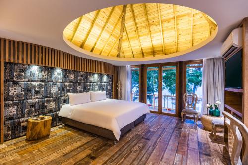 Room with bed, TV, and glass door at one of the best hotels in Barú Island.