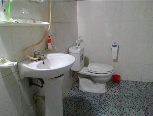 a white toilet sitting next to a sink in a bathroom, Ba Be lake-Huyen Hao Homestay in Ba Be