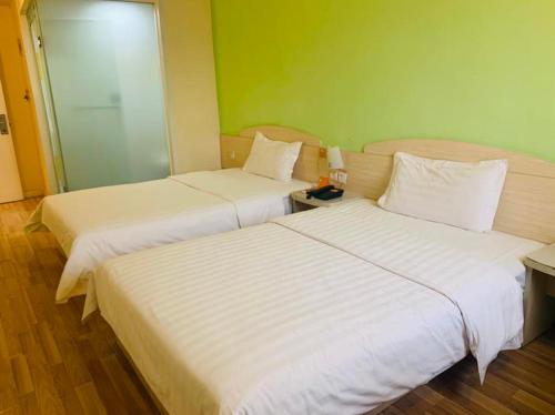 a hotel room with two beds and two lamps, 7 Days Inn Wuhan Guanggu Square Huazhong University of Science and Technology Branch in Wuhan