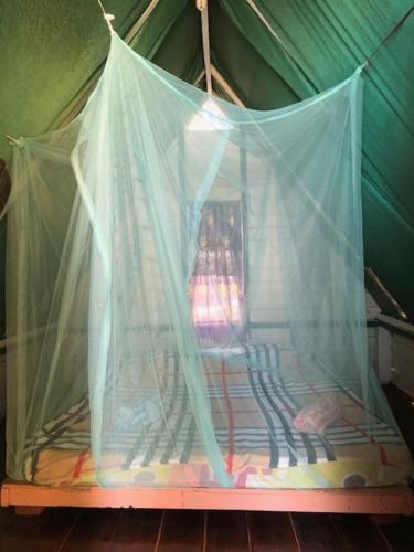 a bed with a canopy on top of it, Beach Shack Chalet - Garden View Aframe Small Unit in Tioman Island