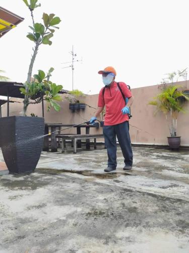 a man holding a baseball bat in one hand and an umbrella in the other, Hotel JSL Johor Bahru in Johor Bahru