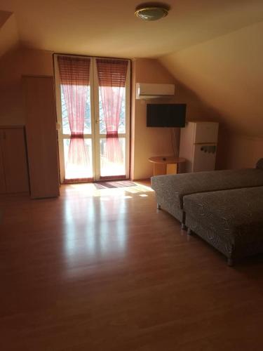 a room with a bed, television and a window, Karika Vendeghaz in Hajduszoboszlo