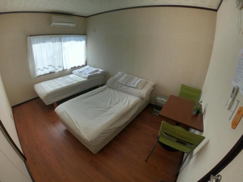 a bedroom with a bed and a desk, Kumano Backpackers in Tanabe
