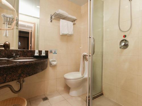 a bathroom with a toilet and a shower stall, GreenTree Inn Suzhou Railway Station South Square Humble Administrator's Garden Business Hotel in Suzhou