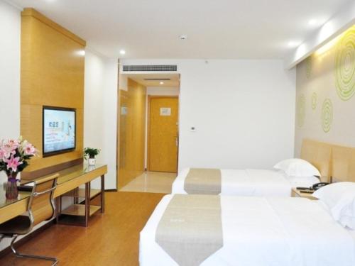 a hotel room with a bed and a television, GreenTree Inn Jiaozuo Mengzhou City Huifeng Road Express Hotel in Jiaozuo