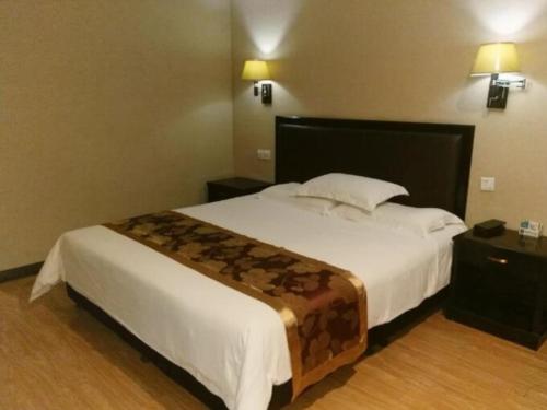 a bedroom with a bed and a lamp, GreenTree Alliance Zhengzhou Railway station West Square Hotel in Zhengzhou