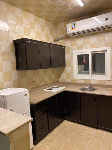 a kitchen with a sink, stove, microwave and cabinets, Al Fanar Al Alamaya 3- Hay'aa Malakeya entrance in Yanbu