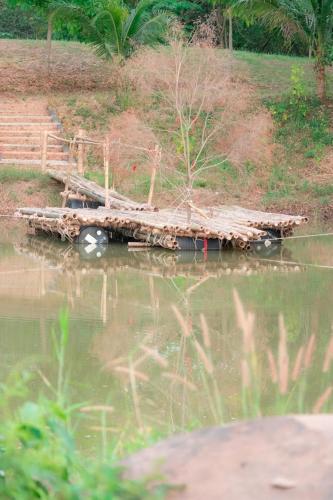 a small boat floating on top of a body of water, The creek villa in Loei