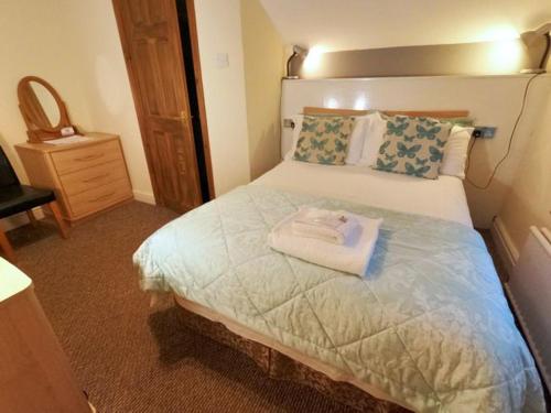 a bed with a white bedspread and pillows, Strands Hotel/Screes Inn & Micro Brewery in Nether Wasdale