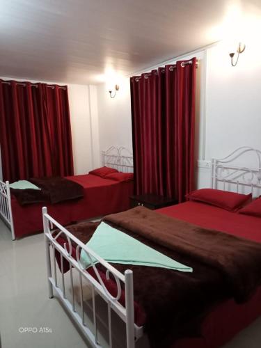 a room with two beds and a red couch, Rani Homestay in Cherrapunji
