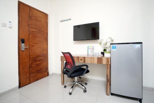 a kitchen with a television and a refrigerator, D'Paragon Seturan 4 in Yogyakarta