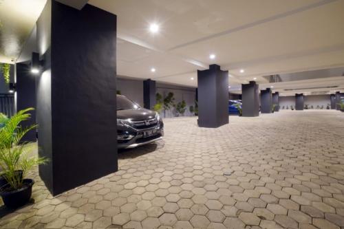 a car parked in a parking lot next to a building, DPARAGON KEBON JERUK in Jakarta