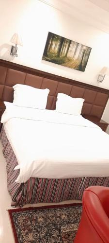 a hotel room with a bed, chair, and pillows, شاطئ الورد 2 قصر البالود 2 سابقا in Jeddah