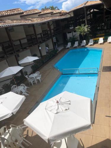 a beach with a pool, chairs, and tables, Hotel Adriattico in Porto Seguro