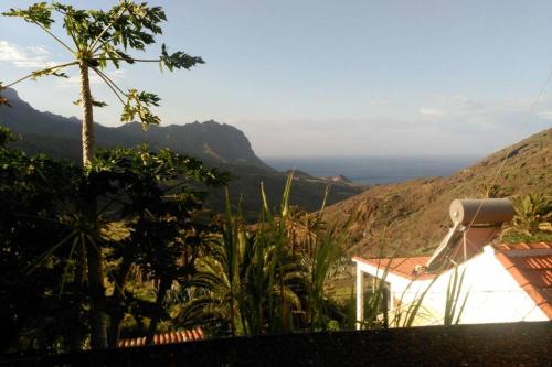 Casa con puesta de sol y montanas.