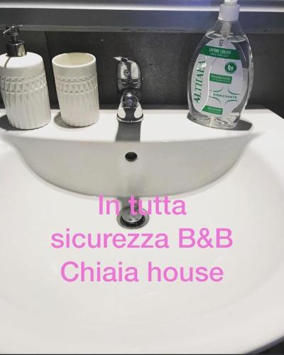 a white sink sitting next to a white toilet, Chiaia House in Naples