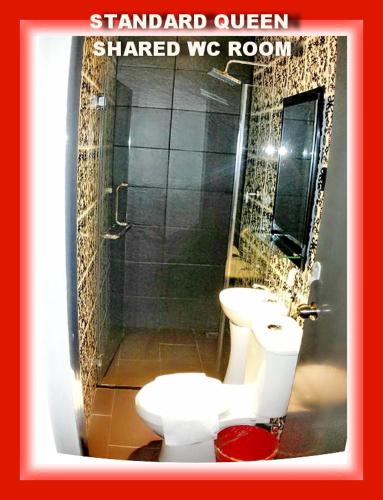 a bathroom with a toilet, sink, and mirror, My Dream Hotel in Sandakan