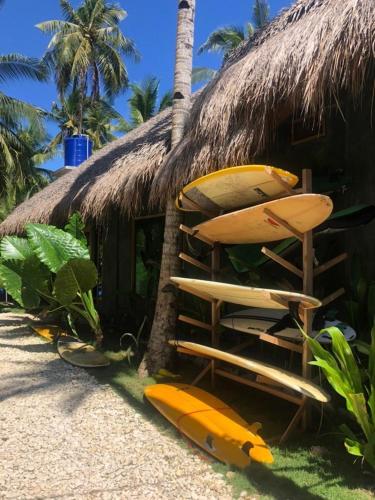 a surfboard sitting on top of a sandy beach, Hiraya Surf Hostel in Siargao Island