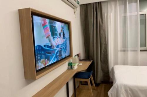 a flat screen tv sitting on top of a wooden table, GreenTree Inn Beijing Chaoyang Shilihe Antique City Express Hotel in Beijing