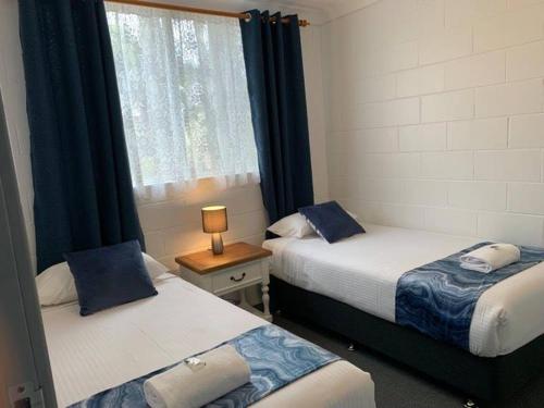 a hotel room with two beds and two lamps, Leisure Tourist Park in Port Macquarie