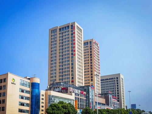 a city with tall buildings and a sky background, Vienna International Hotel Wuhan Jiedaokou Branch in Wuhan