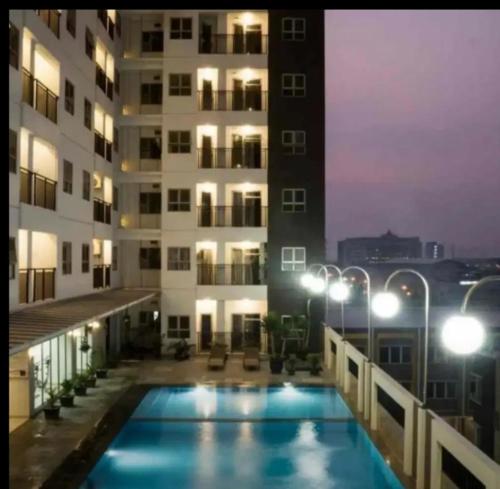 a large swimming pool in front of a large building, Apartemen 2br m-squere Cibaduyut  in Bandung