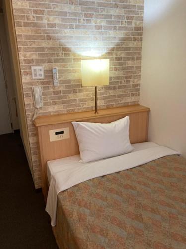 a hotel room with a bed and a lamp, Saga Idaimae Green Hotel in Saga