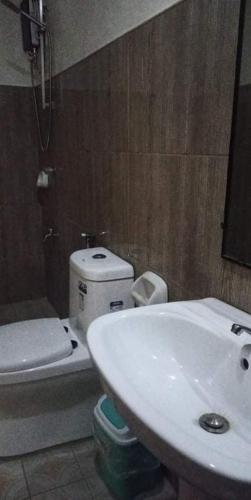 a white toilet sitting in a bathroom next to a sink, MBU Suites Bed n Breakfast in Mangaldan