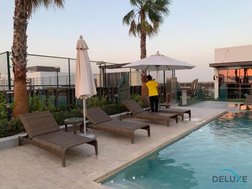 Swimming pool, Extensive 3BR Townhouse at Janusia Damac Hills 2 by Deluxe Holiday Homes in Damac Hills 2