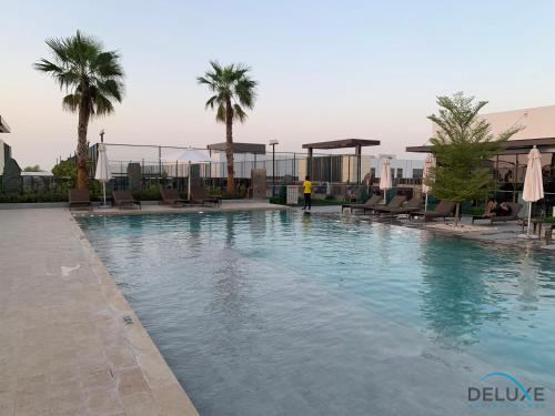 Swimming pool, Extensive 3BR Townhouse at Janusia Damac Hills 2 by Deluxe Holiday Homes in Damac Hills 2