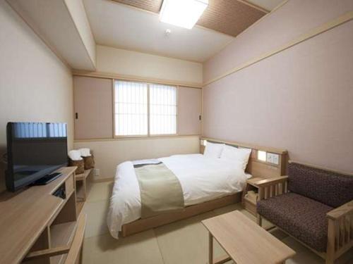 a room with a bed, chair, desk and a tv, Sakaiminato Onyado Nono Natural Hot Spring in Yonago