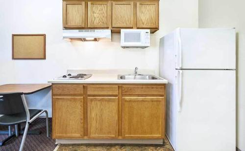 a kitchen with a refrigerator, stove, sink and microwave, WoodSpring Suites Champaign near University in Champaign (IL)