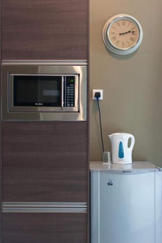 a kitchen with a microwave and a clock, Empihaus 001 Empire Damansara in Kuala Lumpur