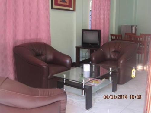 a living room filled with furniture and a tv, Jared Suites in Digos