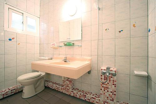 a white toilet sitting next to a sink in a bathroom, Da Wan Hostel in Kenting