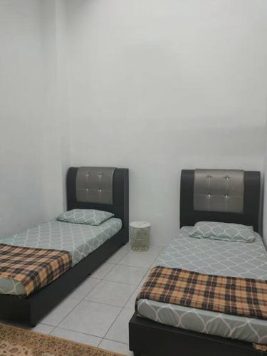 a hotel room with two beds and two night stands, DEENA HOMESTAY JERANTUT, FREE UNIFI in Jerantut