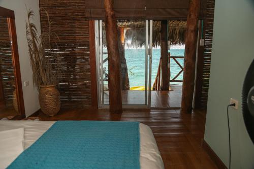 Small room with doors open overlooking a balcony and sea at a Barú Island resort.