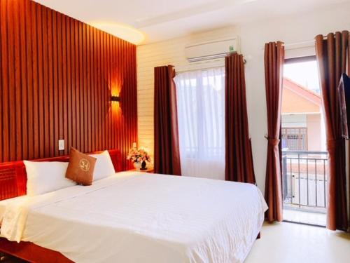 a bedroom with a large bed and a large window, Poetic Hue Hotel in Hue