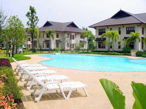 a patio area with chairs, tables, and lawn chairs, Teak Garden Spa Resort in Chiang Rai
