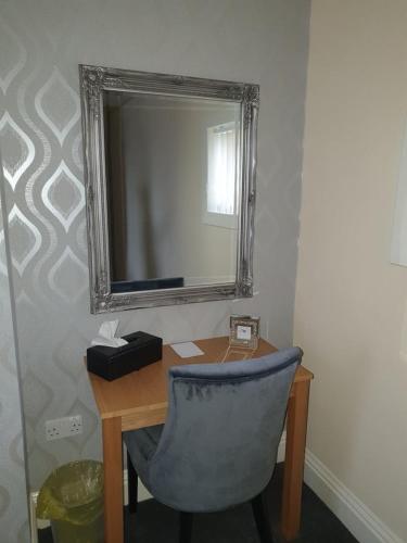 a chair sitting in front of a mirror in a room, Hawthorn House in Blackpool
