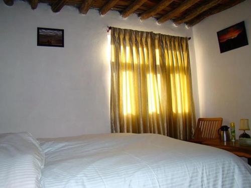 a bedroom with a bed and a window, The Nomad's Cottage-Losar, Chandra Tal - Spiti Valley in Losar