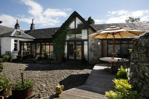 a house with a patio table and a balcony, Sheildaig Farm in Balloch