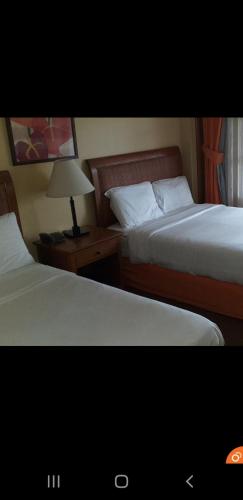 a hotel room with two beds and a lamp, PRIVATE unit CAMP JOHN HAY MANOR in Baguio