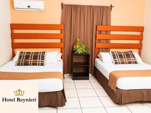 two beds in a room with a white bedspread, Hotel Reynieri in Tegucigalpa