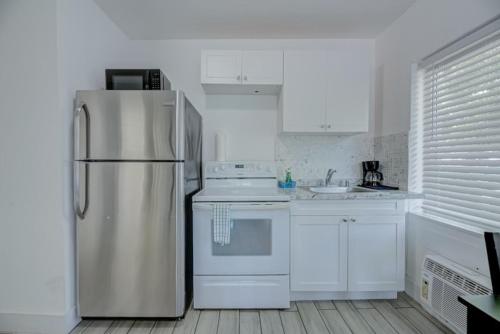a kitchen with white cabinets and white appliances, Adorable private apartments in the Heart of Miami! in Miami (FL)
