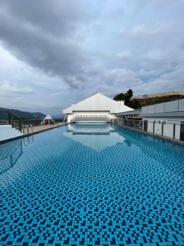a swimming pool with a blue sky and blue walls, Sekata Apartment in Cameron Highlands
