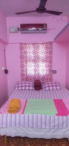 a bedroom with a pink bedspread and pink walls, Villa Bonny Home Stay in Pondicherry