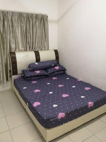 a bed with a blue and white comforter and pillows, Adieza Homestay Dmuslim only in Malacca